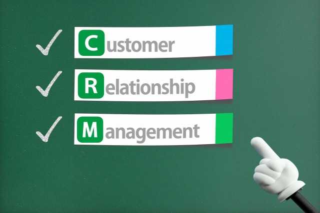 黒板に書かれたCustomer Relationship Managementと指し棒